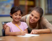 It takes a big heart to shape little minds. a teacher helping her student with her work in the classroom